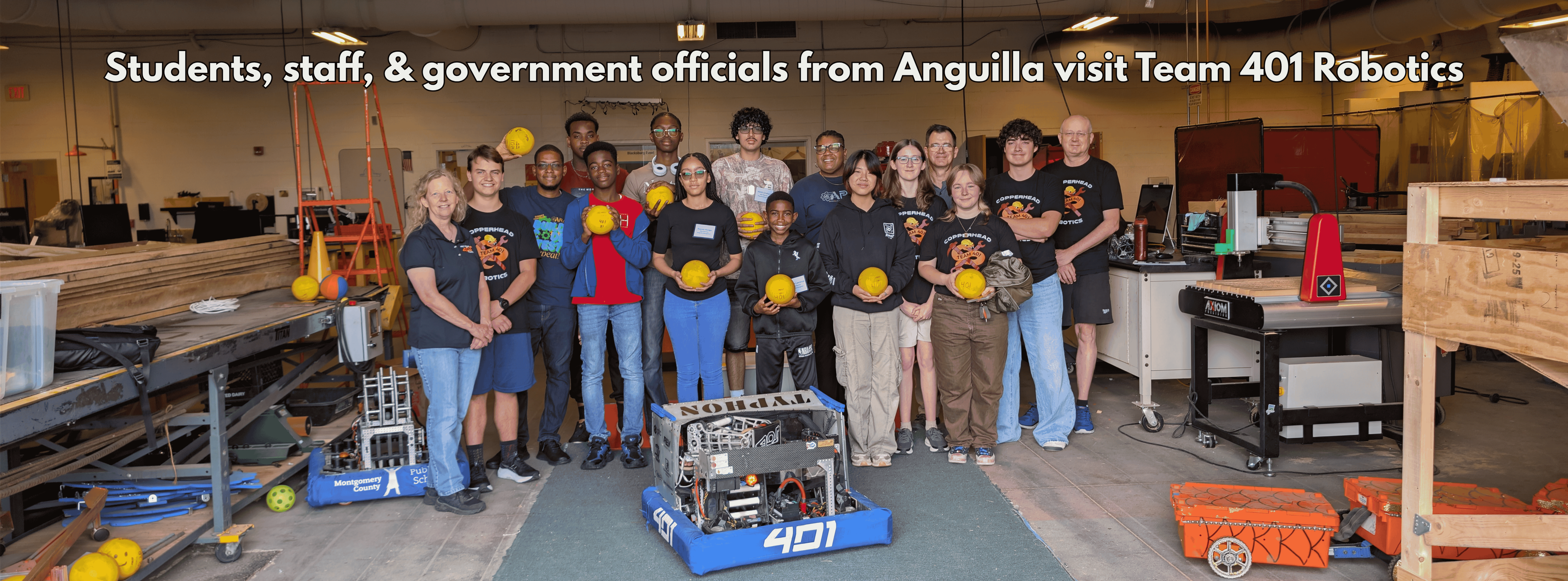 wide shot of students with text that says "Team 401 robotics hosts students, staff and government officials from Anguilla