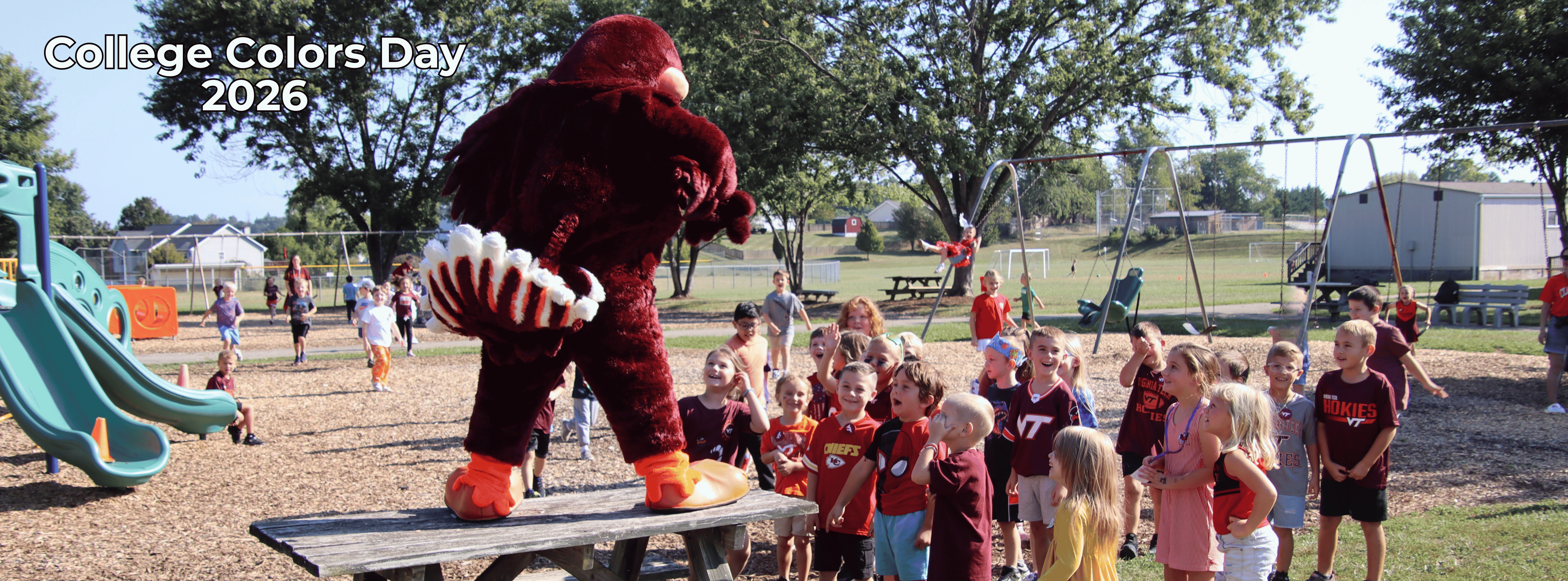 Hokie Bird standing on a table interacting with kids