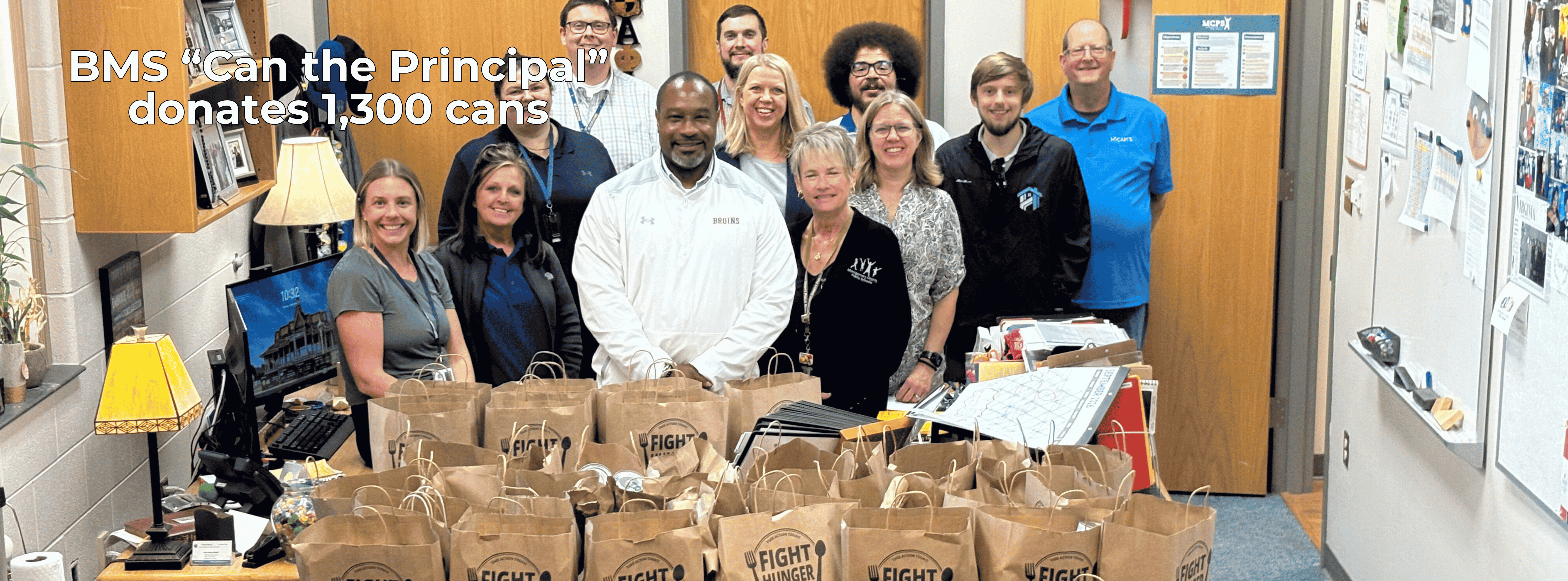 bms staff standing behind bags of canned goods