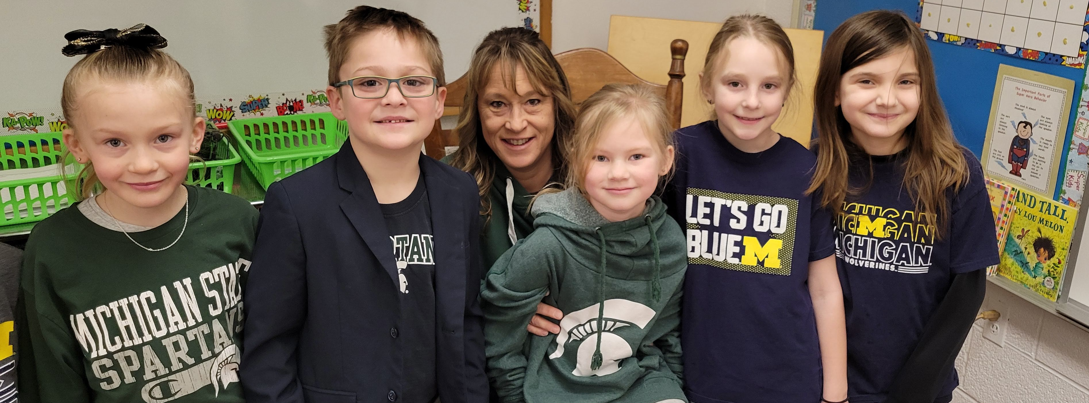 Teacher and students in Michigan and Michigan State shirts