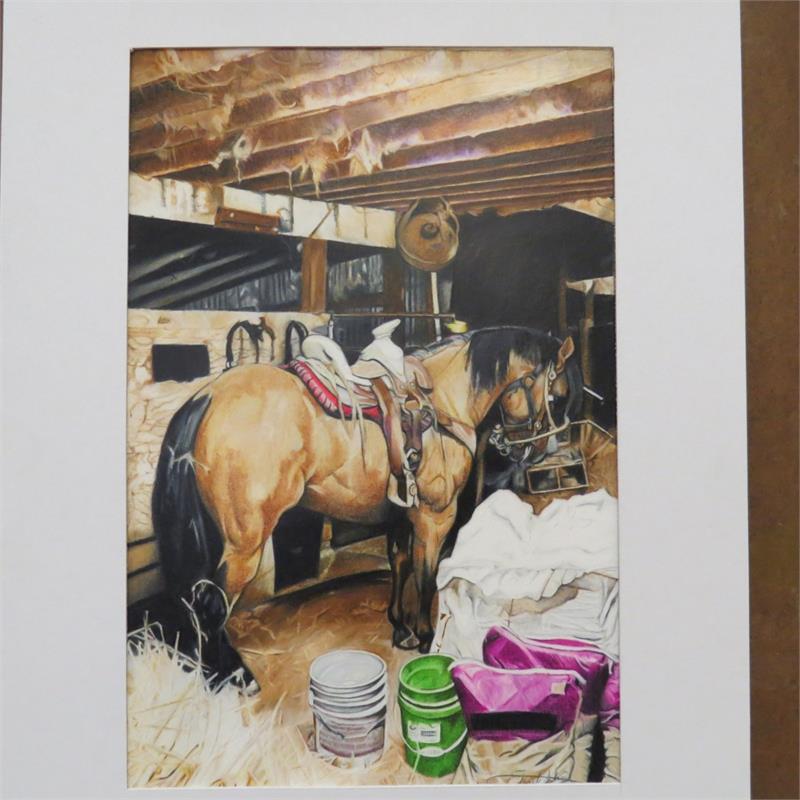 A horse stands in a barn, saddled and ready, surrounded by hay and various buckets in a rustic setting.