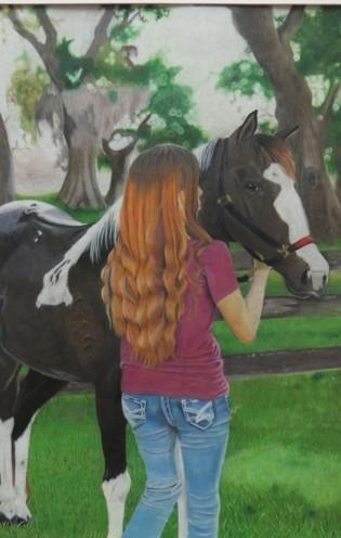 A girl with long hair stands beside a black and white horse in a grassy area, surrounded by trees.