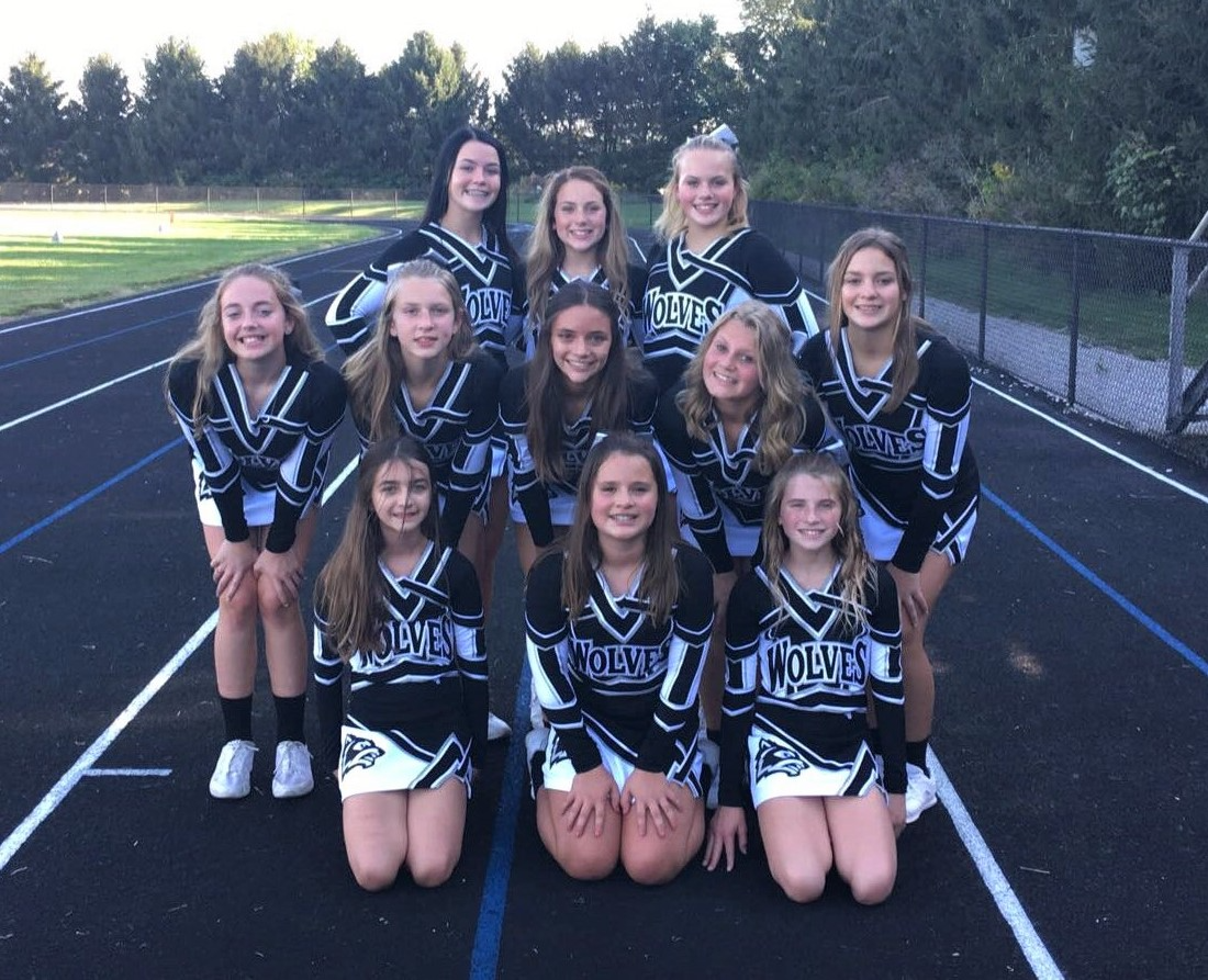  Cheerleaders pose together on the track, showcasing their team spirit and enthusiasm for the event.