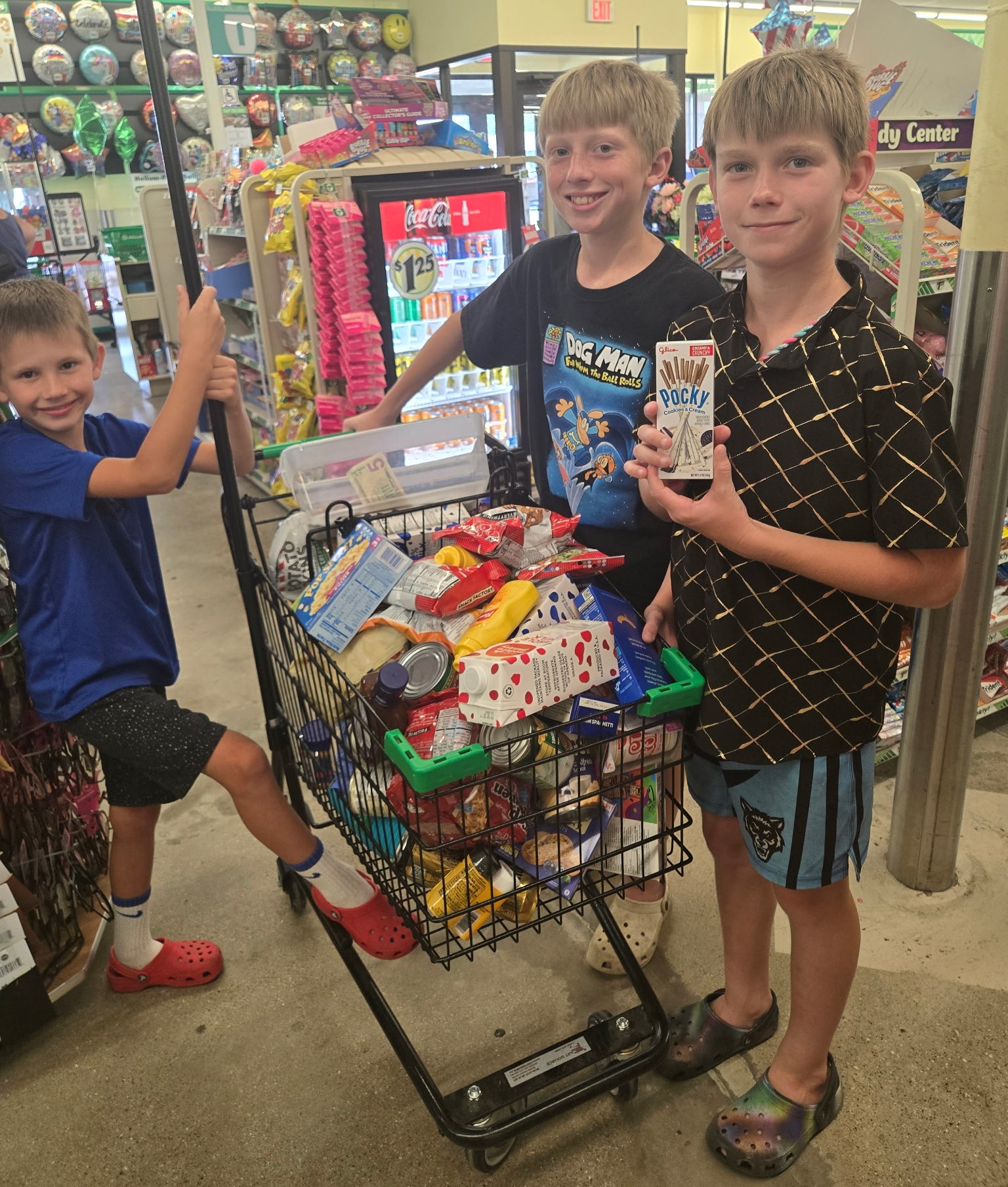 three boys purchasing items at the grocery store