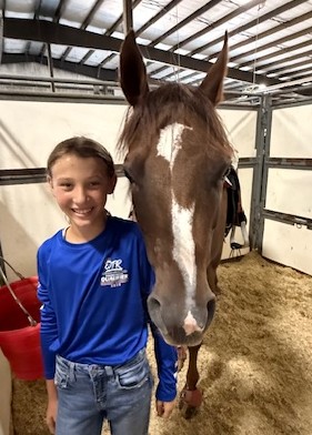girl standing by her horse