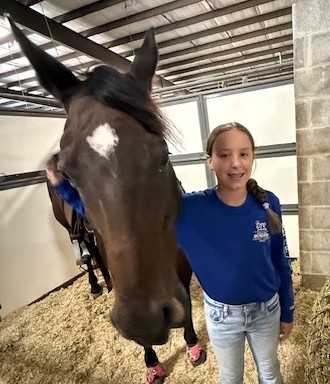 girl standing by a horse