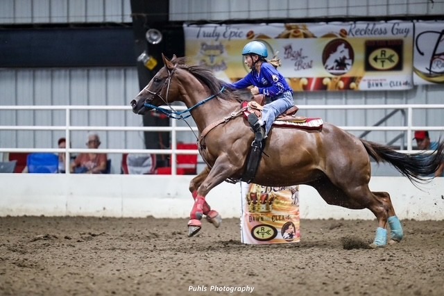 a girl riding a horse barrel racing