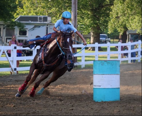 a girl riding a horse barrel racing