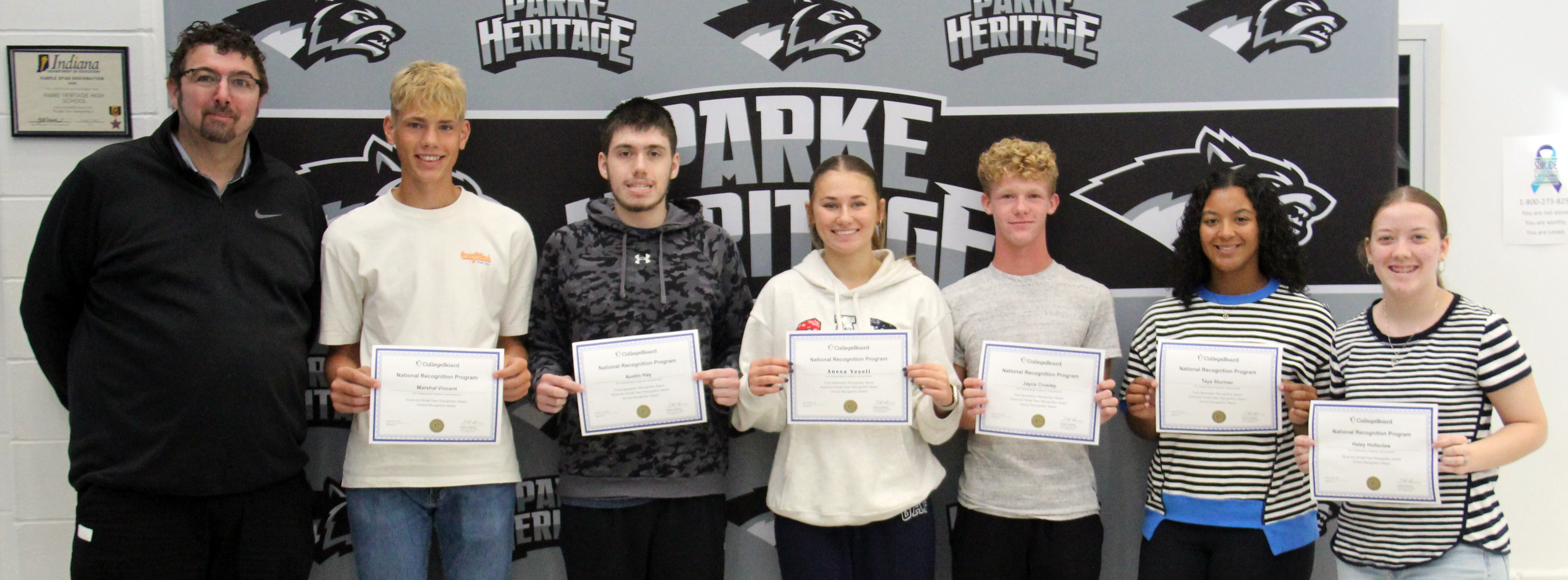 six students standing and holding certificates along with the HS principal