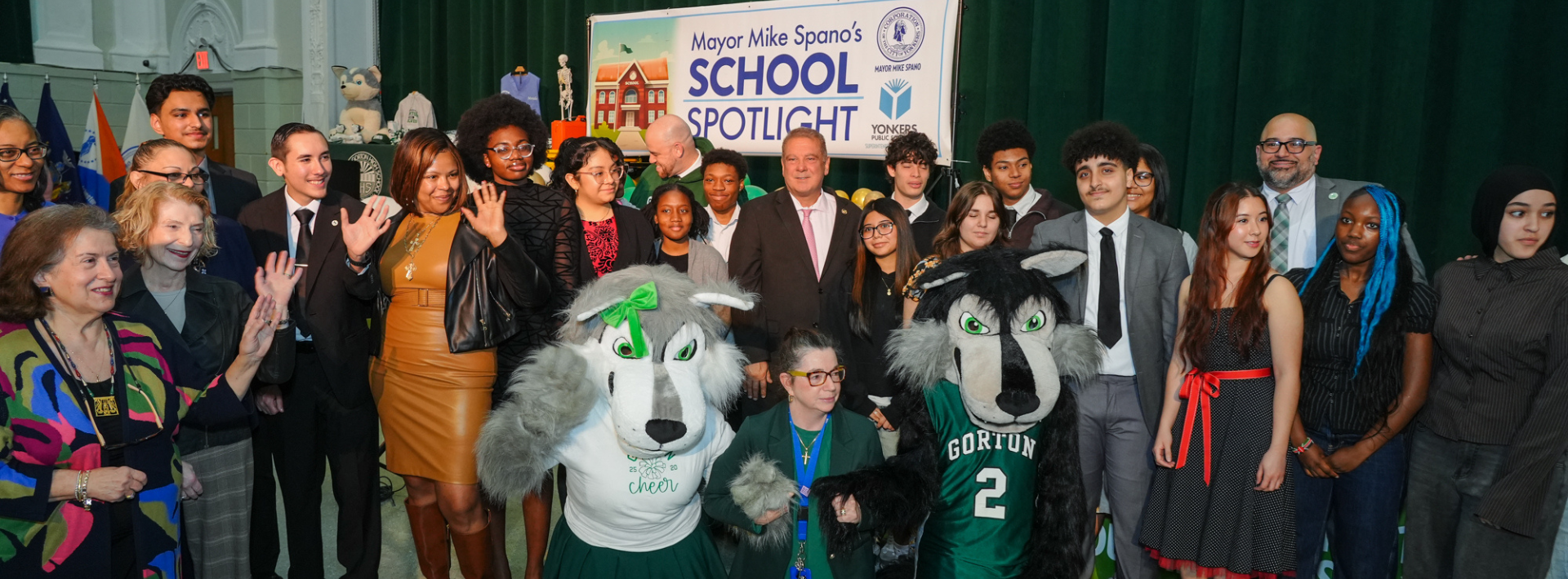Group photo of students, staff, and officials at Mayor Mike Spano’s School Spotlight event, with Gorton High School mascots and a “School Spotlight” sign in the background.