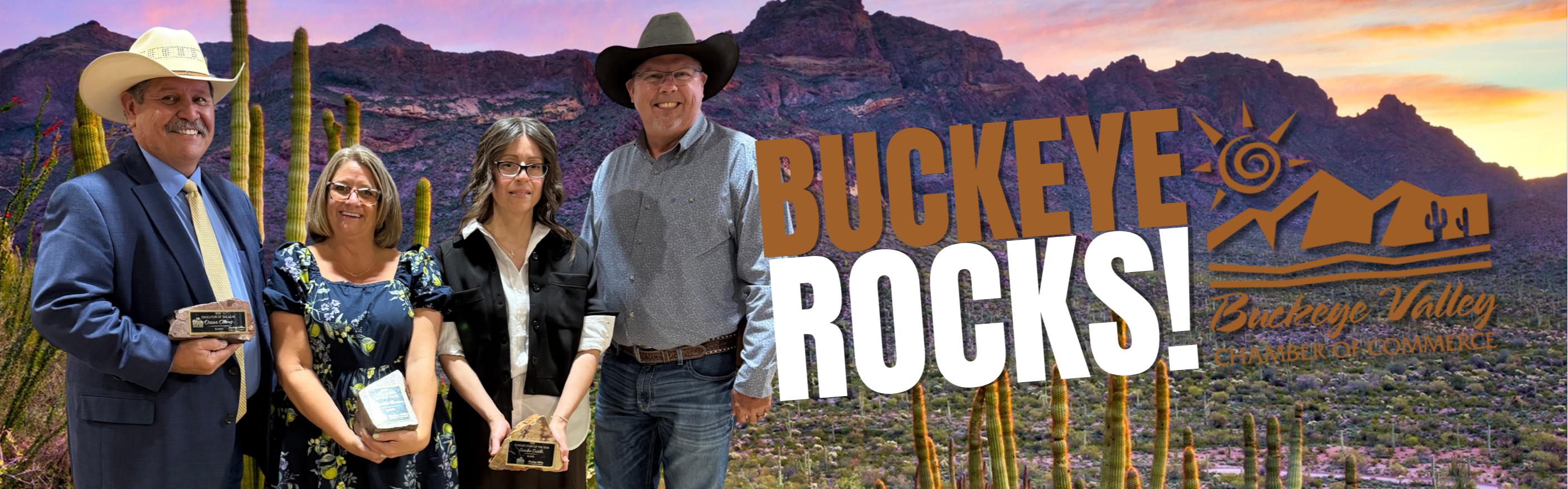 Five people stand in front of mountains and cactus, smiling and holding awards. The words Buckeye Rocks! are displayed.