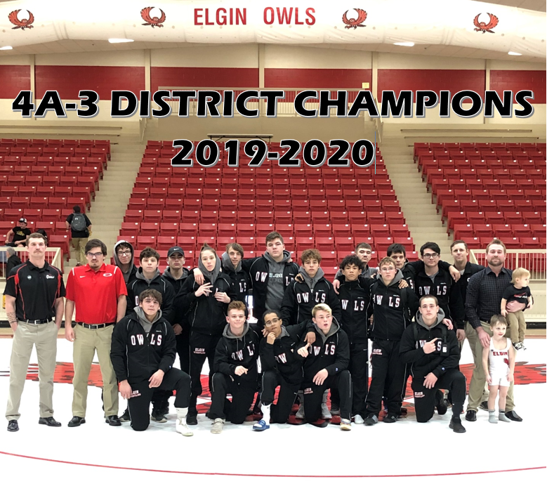 A group photo of the Elgin Owls wrestling team celebrating their 4A-3 District Championship for the 2019-2020 season, with team members posing together on a wrestling mat in a gymnasium.