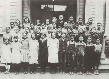 A vintage black and white photograph featuring a group of children, capturing their joyful expressions and playful demeanor.