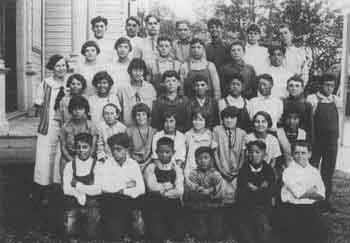 A vintage black and white photograph featuring a group of children, capturing their joyful expressions and playful demeanor.