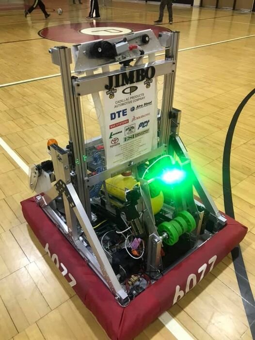 A robot stands on a basketball court, illuminated by a vibrant green light, showcasing a futuristic sports scene.