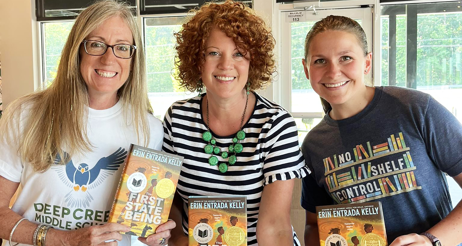 three teachers holding up books