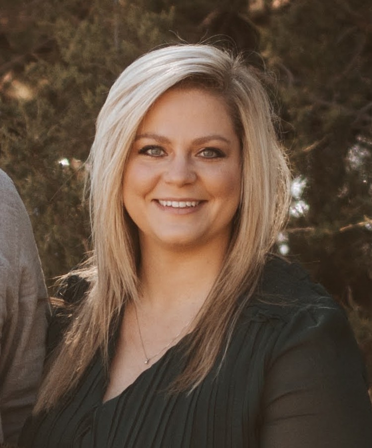 A woman and a man are positioned next to each other, both appearing cheerful in a casual environment.