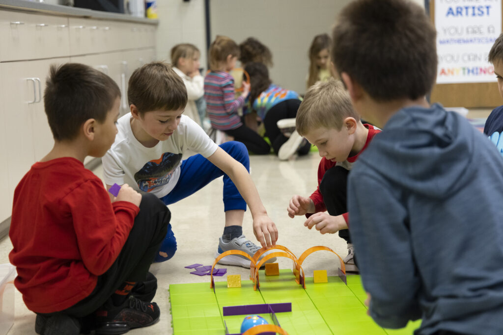 Children engaged in play with a toy in a vibrant classroom setting, fostering creativity and social interaction.