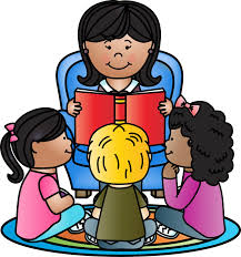 A woman reads a book to four children sitting on a colorful rug, with two girls and a boy in front and one girl to the side, all attentively listening.