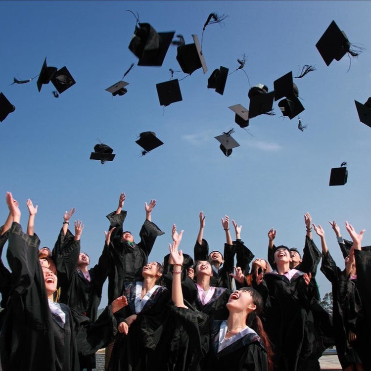 students throwing graduation caps