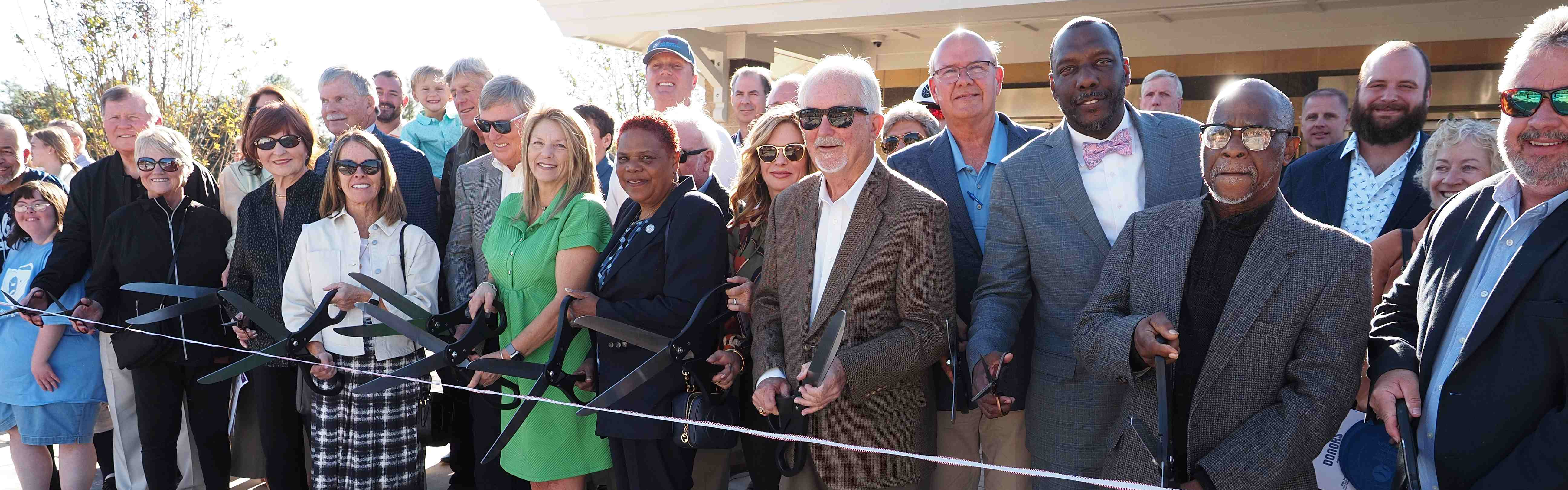 board members and community cutting ribbon