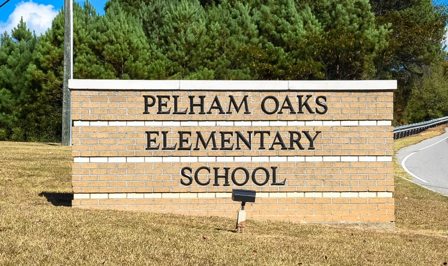 Pelham Oaks Elementary School building with playground and trees, showcasing a vibrant learning environment for children.