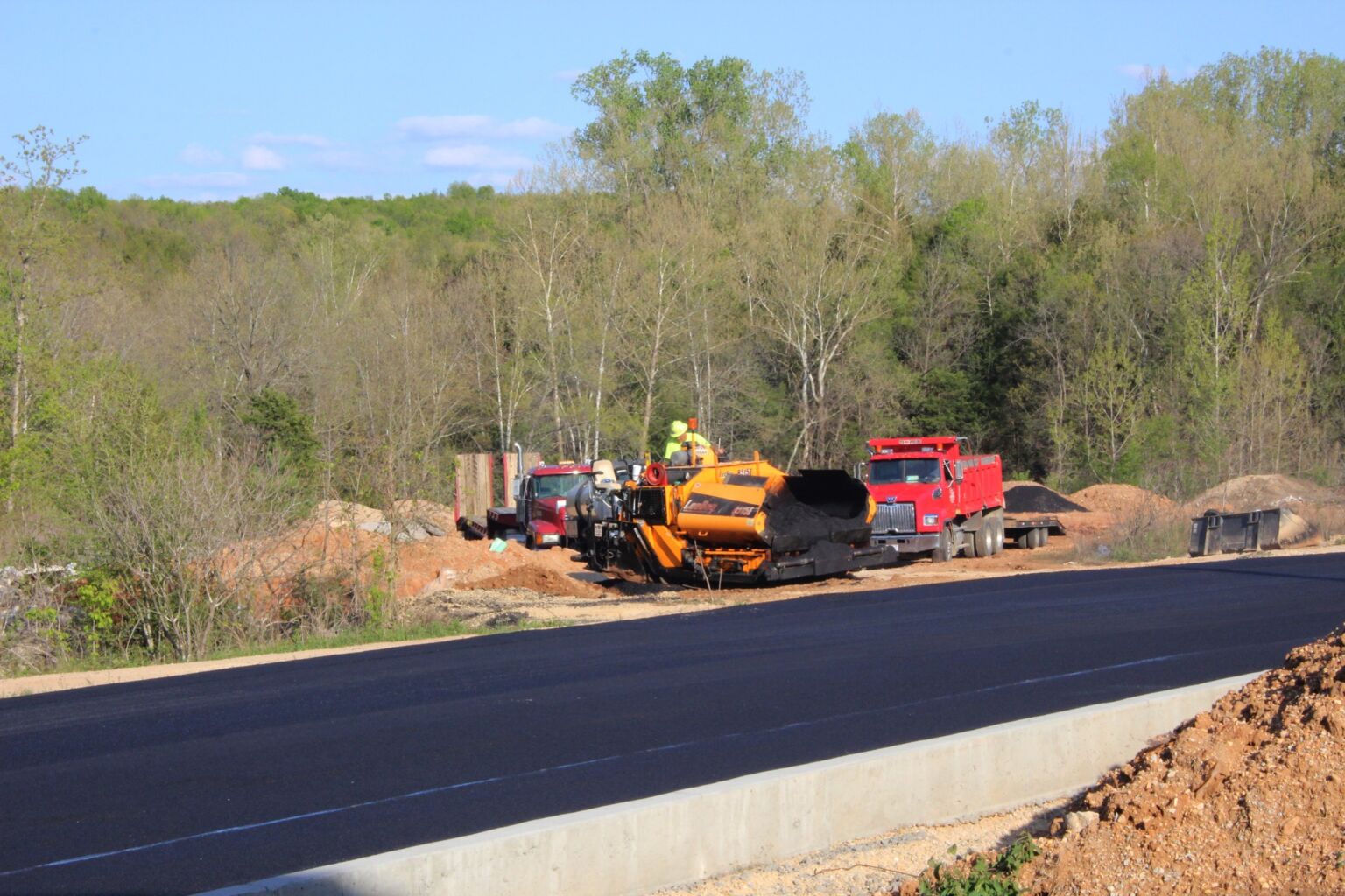 A construction crew is actively working on a road, using machinery and tools to improve the infrastructure.