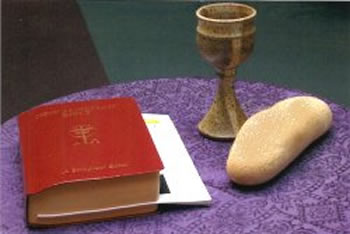 A Bible accompanied by a piece of bread and a wine glass, representing the sacred elements of faith and fellowship.