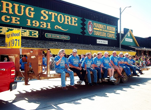 A group of individuals seated on the back of a truck, enjoying a moment together outdoors.