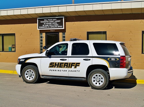 A sheriff's department car parked near a building, representing the authority and vigilance of local law enforcement.