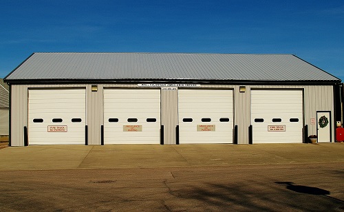 . A sizable garage equipped with three doors and a durable roof, ideal for housing multiple vehicles and tools.