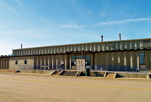A large industrial building with a spacious parking lot, showcasing a modern architectural design and ample vehicle space.