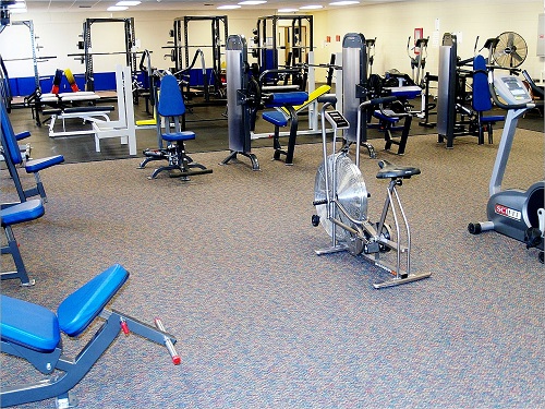 A well-equipped gym room featuring various exercise machines and fitness equipment for workouts and training sessions.
