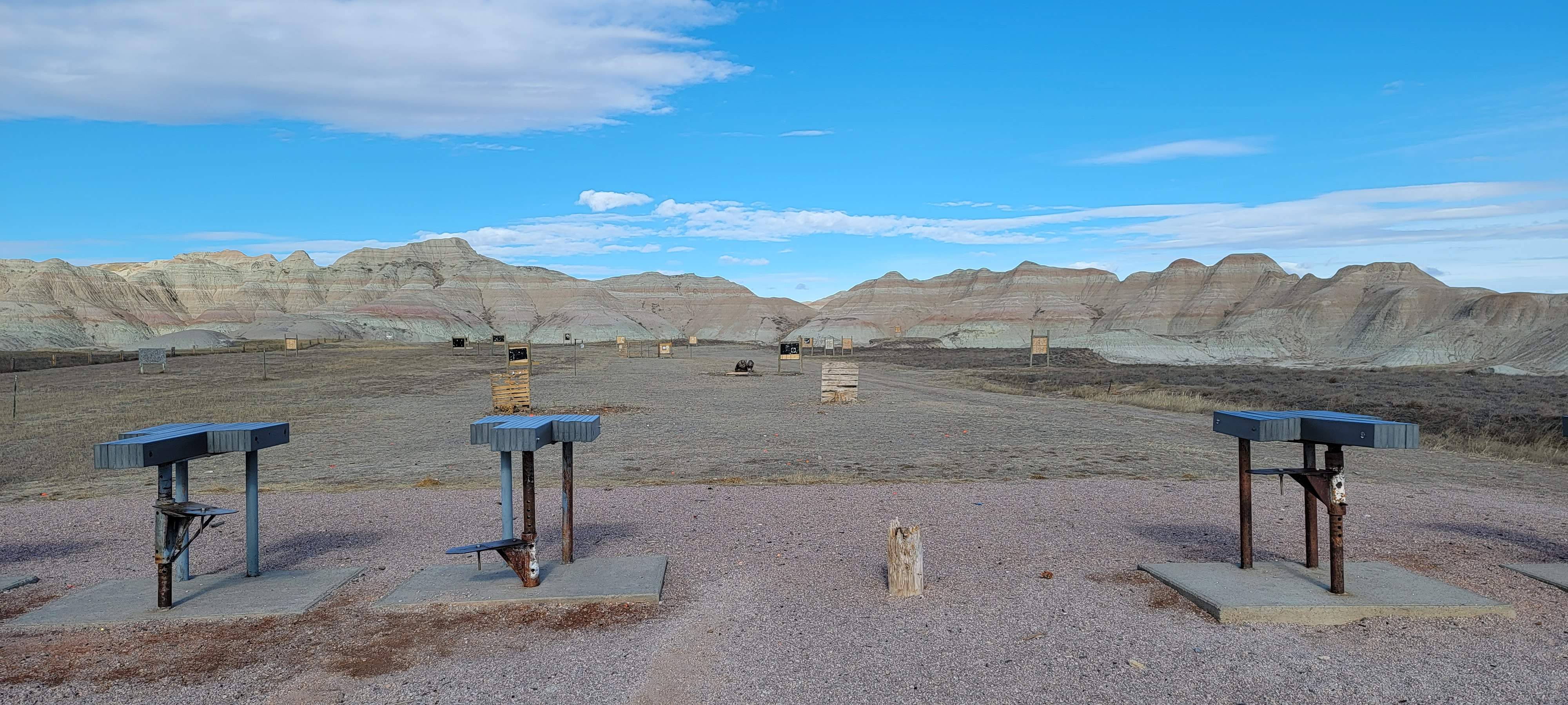 A cluster of benches situated in a vast desert landscape under a clear blue sky.