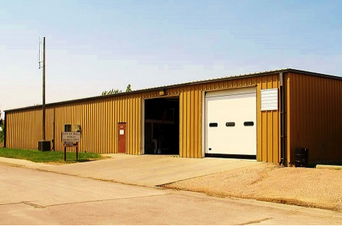 A large metal building with an open garage door, revealing the interior space and showcasing its industrial design.