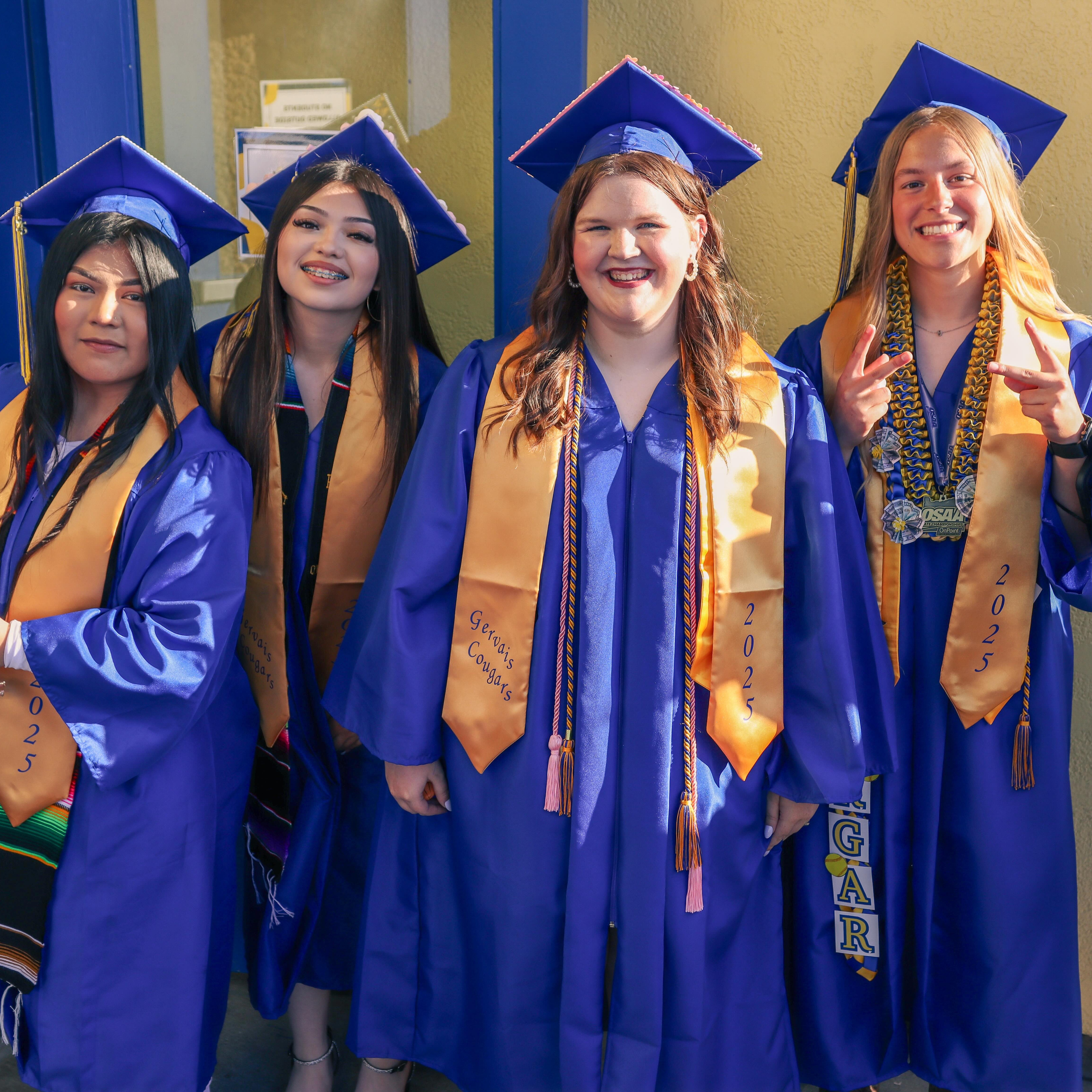 four students in graduation attire