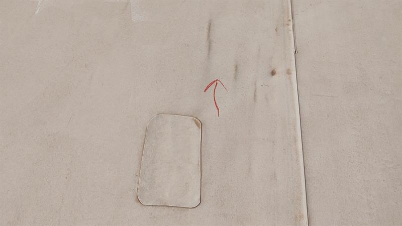 An aerial view of a concrete surface showing a rectangular patch with red markings nearby.