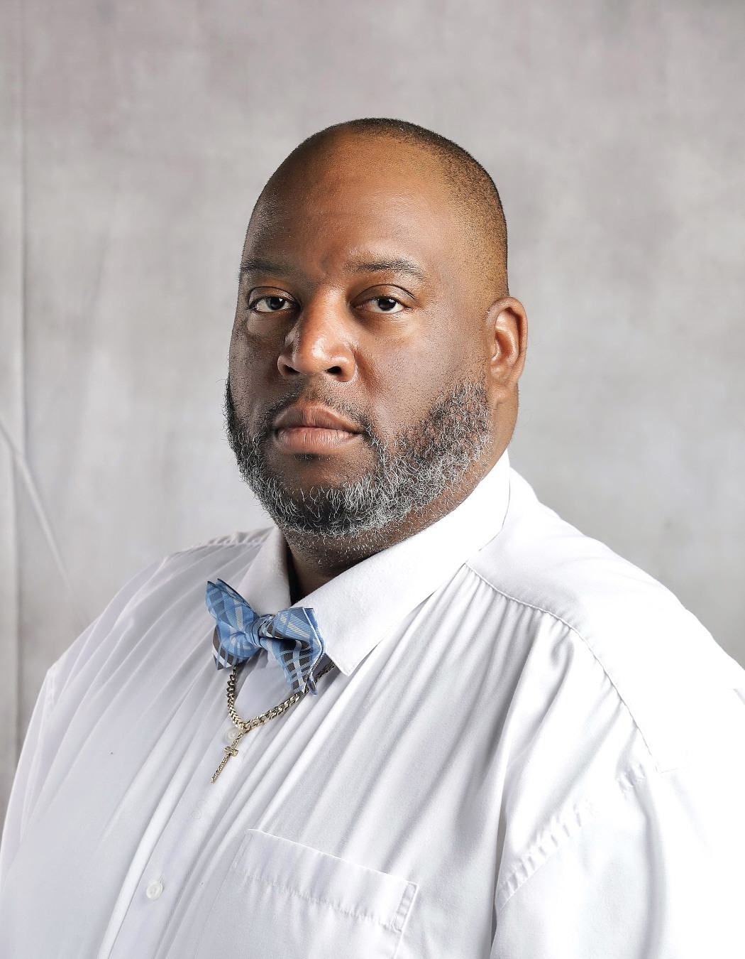 Wilhelm johns: Professional portrait of a man wearing a white dress shirt and blue patterned bow tie.