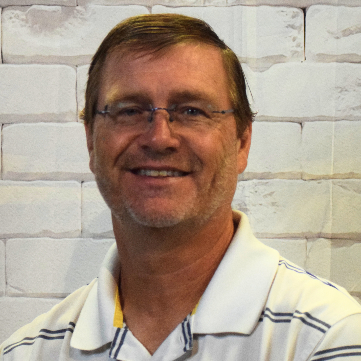  A man wearing a gray shirt with a green cross displayed prominently on his chest.