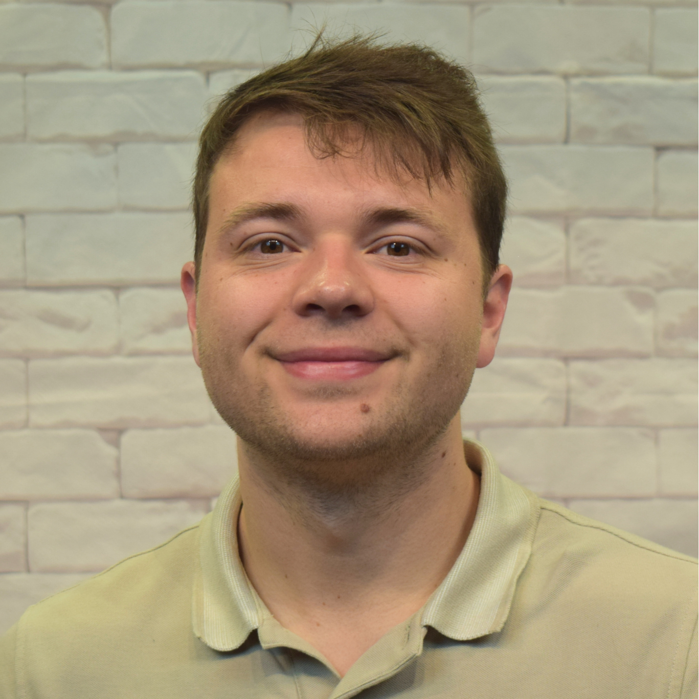 A young man dressed in a white shirt and a purple tie, exuding a professional and polished appearance.