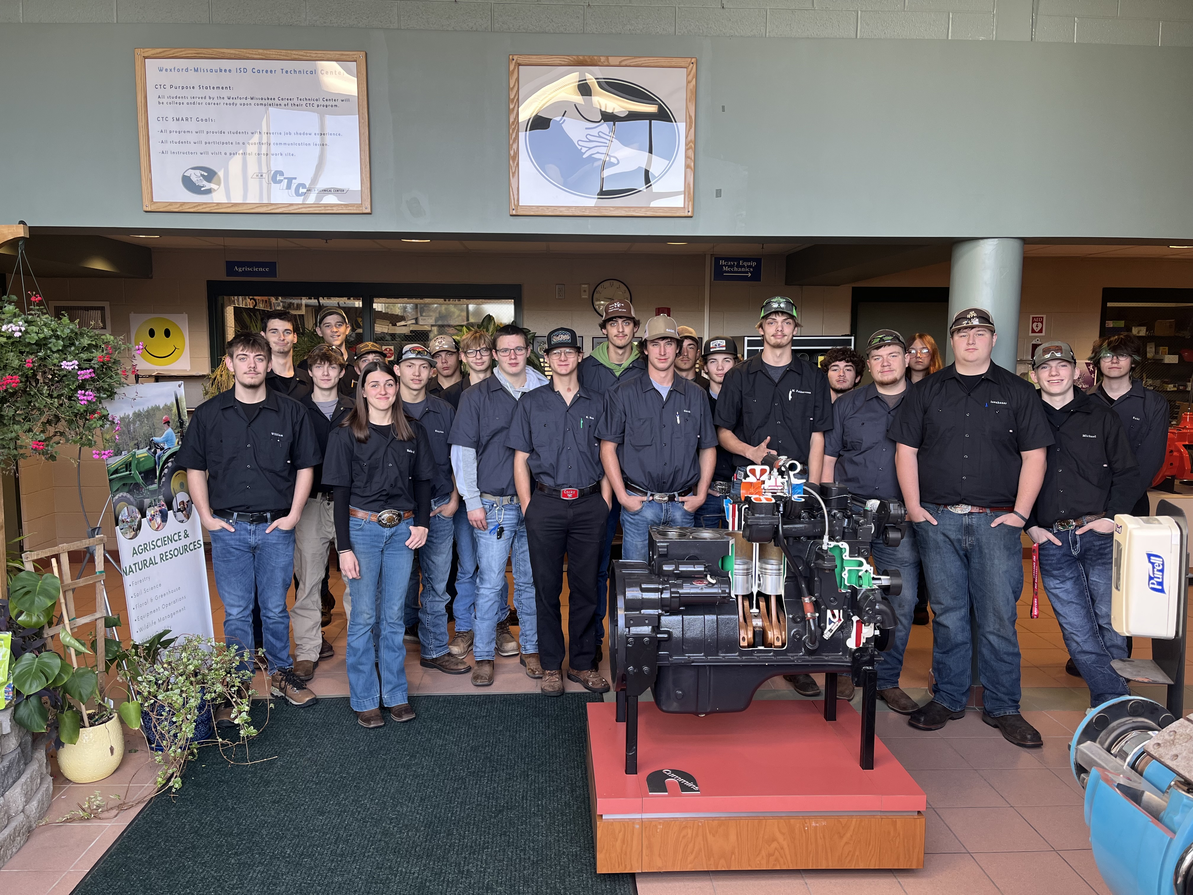 Students standing in front of an engine.