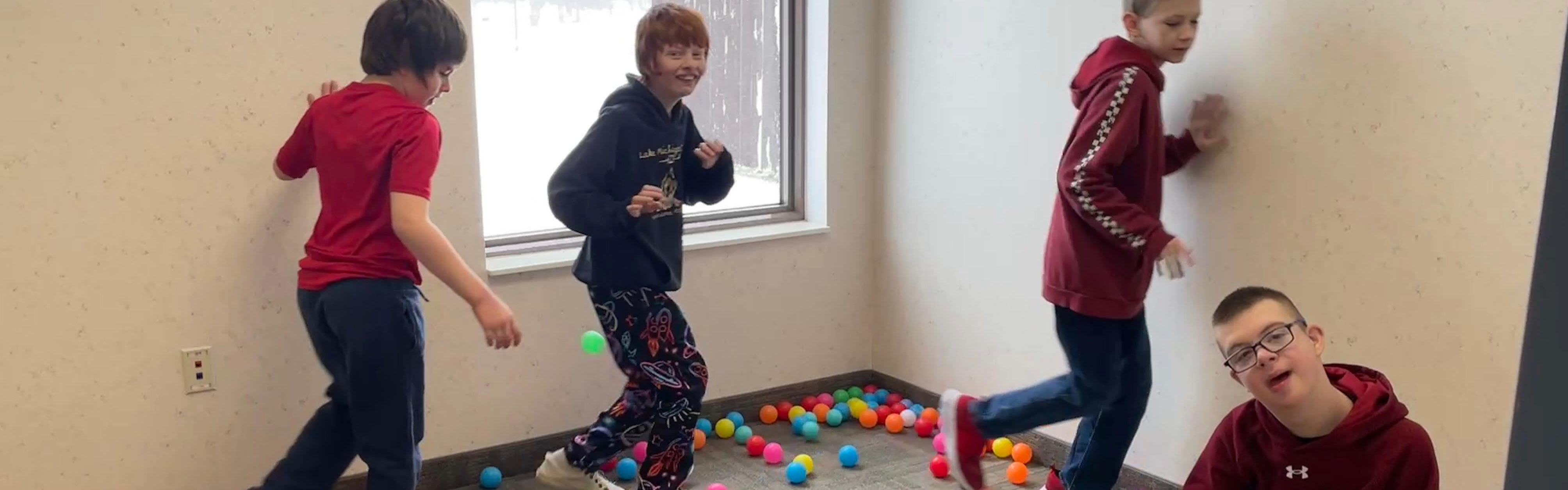 Students playing with balls on the floor.