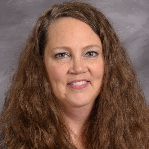 A woman wearing a leopard print top paired with a black cardigan, exuding a stylish and confident appearance.