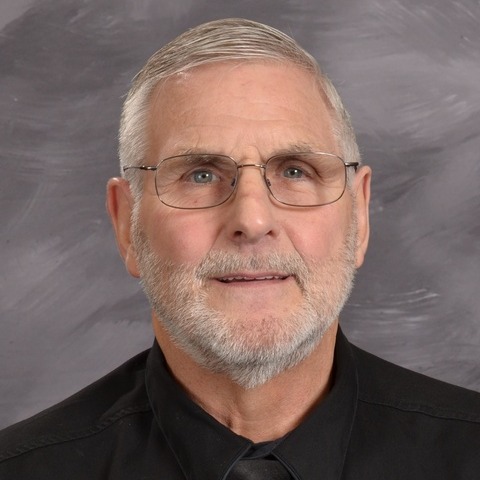 A smiling man wearing glasses and a tie, exuding confidence and professionalism.