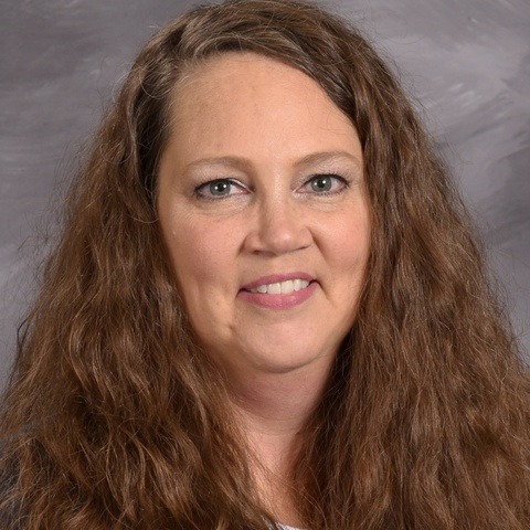 A woman wearing a leopard print top paired with a black cardigan, exuding a stylish and confident appearance.