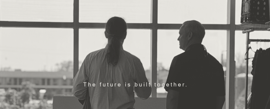 Two men talking about the future standing at a window of a classroom