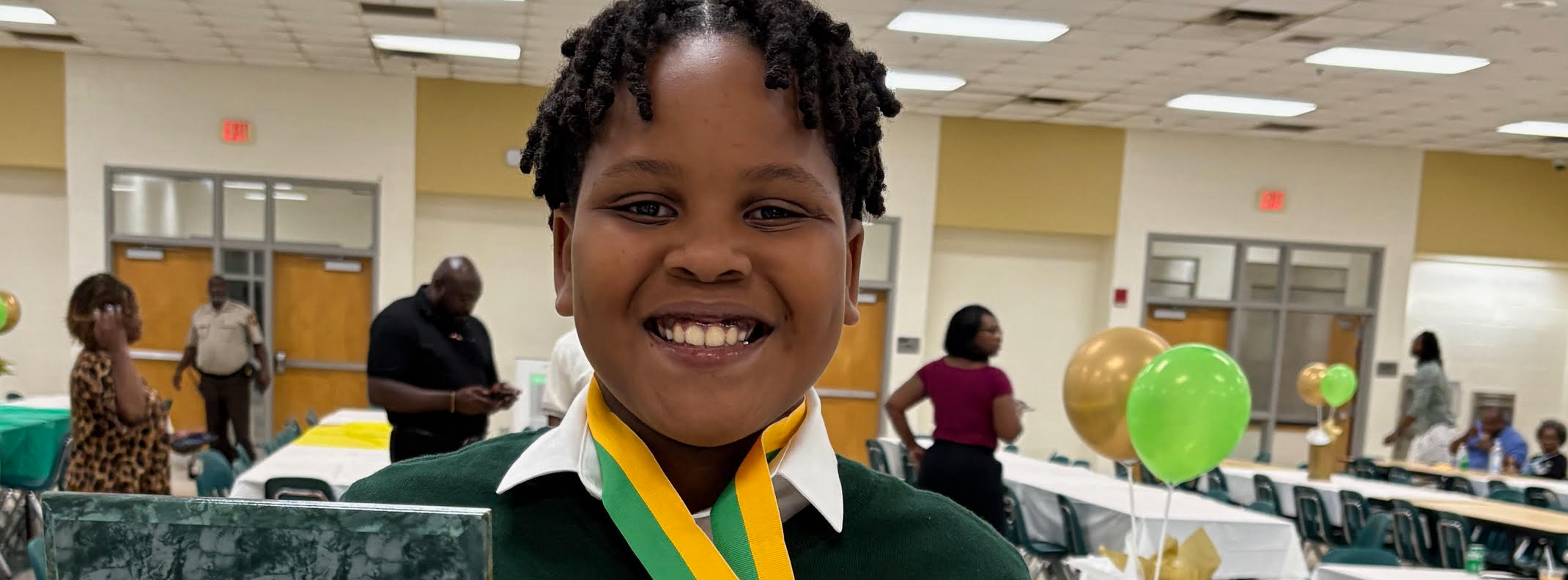 student smiling with an award
