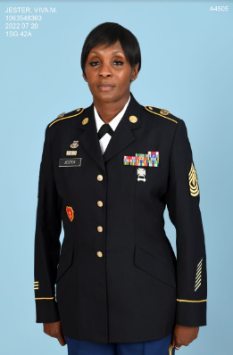 A woman in military uniform stands confidently, posing for a photo with a proud expression.