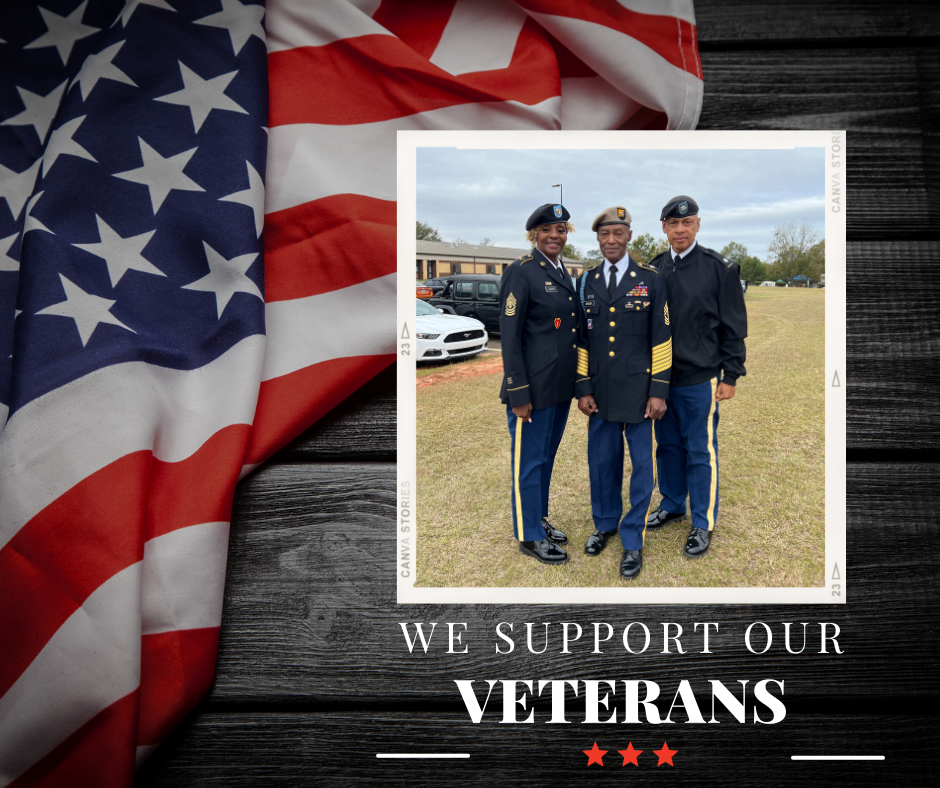 A group of diverse individuals holding a banner that reads "We Support Our Veterans," showcasing unity and appreciation.