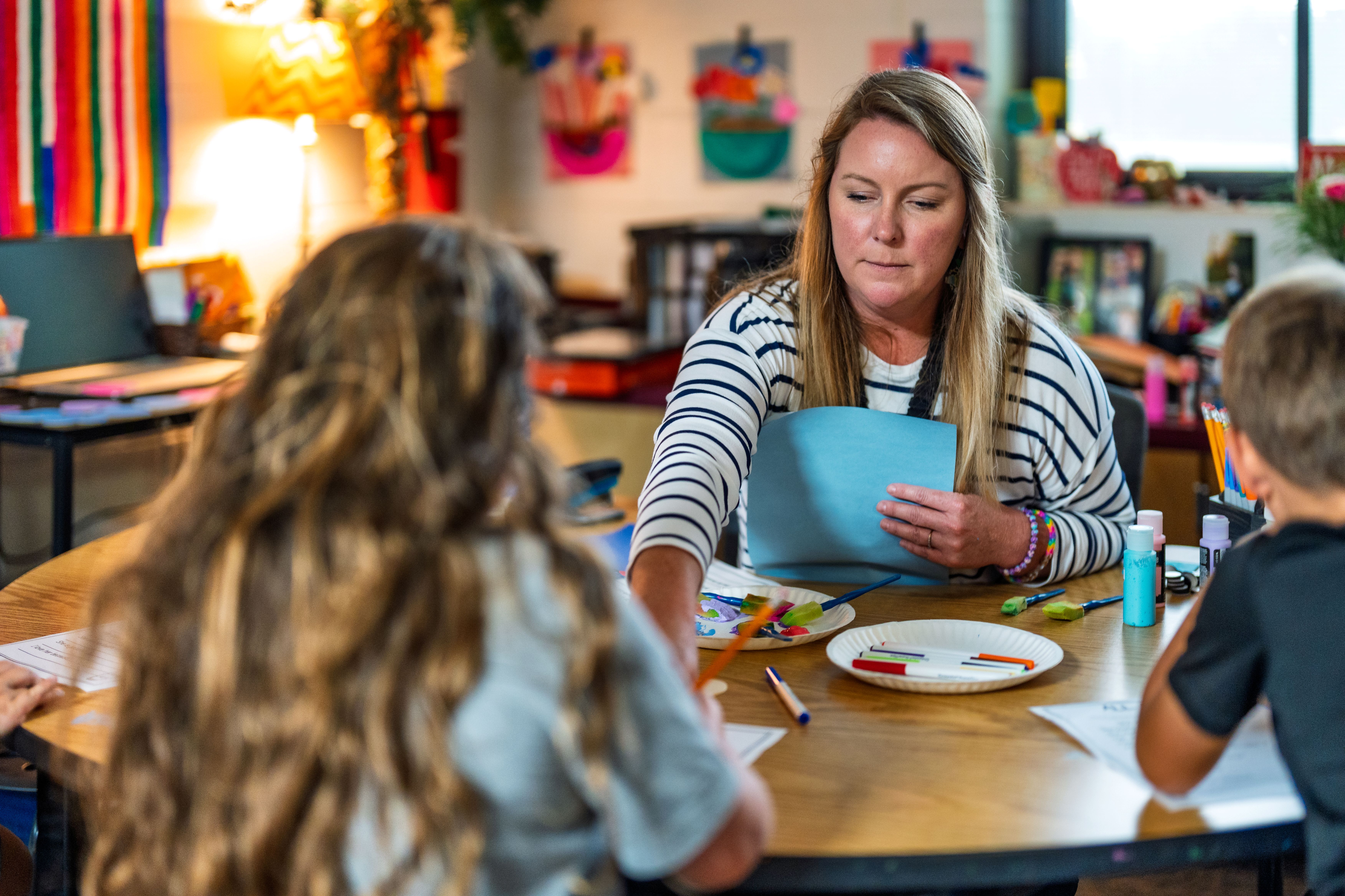 Teacher working with student at desk for small group.